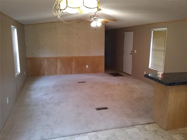 en empty room with windows and ceiling fan