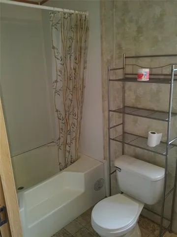 a white toilet and shower