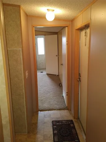 a view of a hallway with wooden floor and closet area
