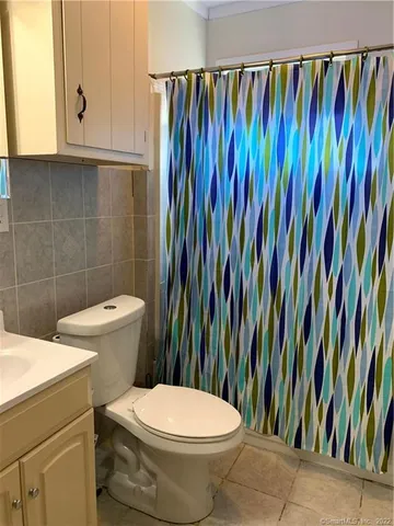 a bathroom with a toilet and a shower curtain