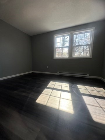 15-17 Otis Court, Unit 15 Springfield, MA 01119 - Photo 10 of 16 an empty room with wooden floor and windows