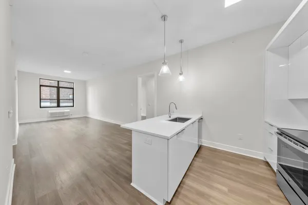 a view of a kitchen sink and wooden floor