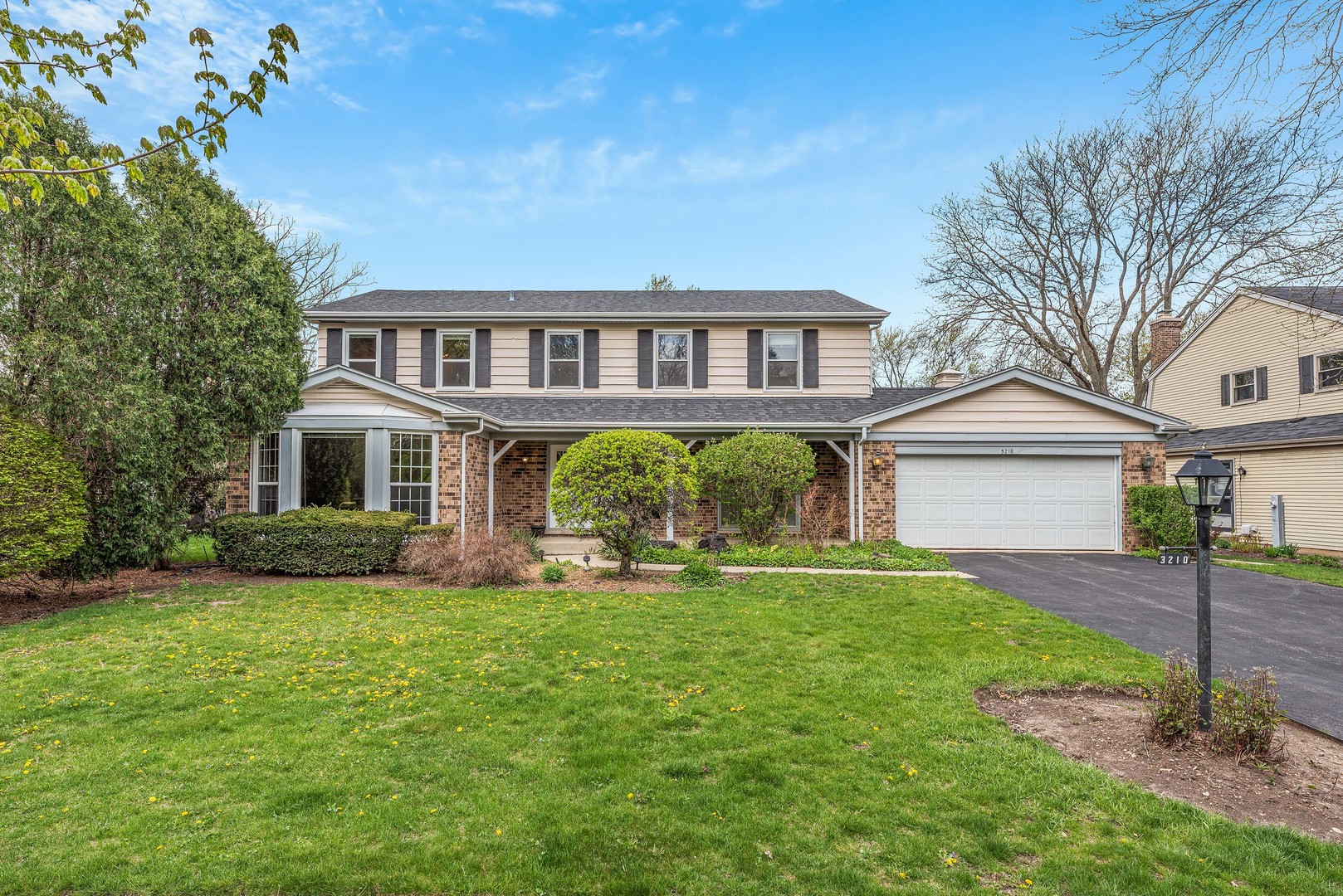 a front view of a house with a garden and yard