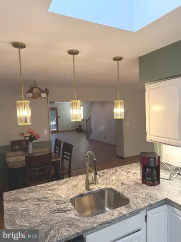 a kitchen with kitchen island a sink and a chandelier