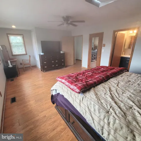 a bedroom with a bed and a large mirror on the dresser