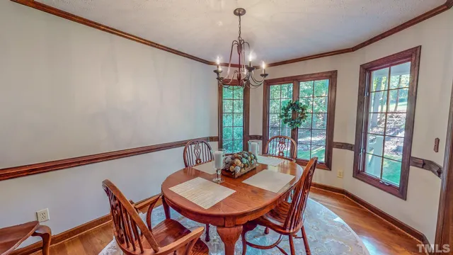 a view of a dining room with furniture a chandelier and wooden floor