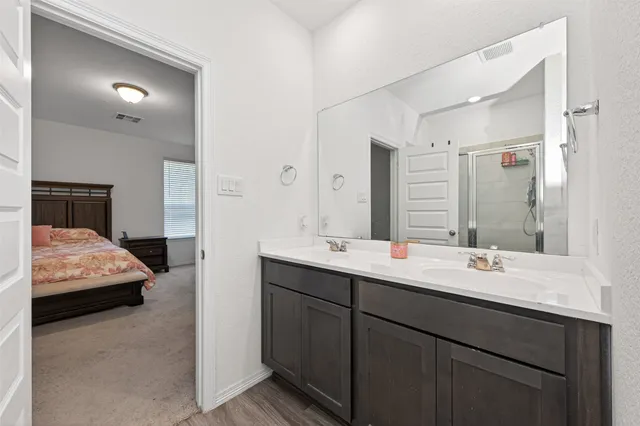 a en suite bathroom with a double vanity sink and mirror