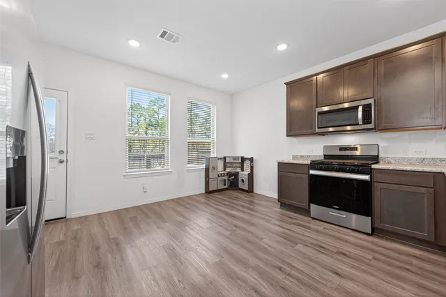 a kitchen with stainless steel appliances a stove a sink and a microwave