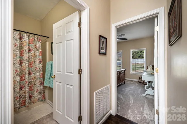 a view of a hallway with workspace and wooden floor