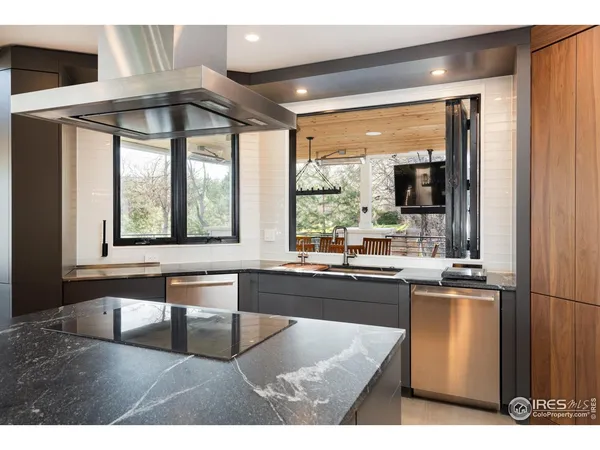 a kitchen with kitchen island granite countertop wooden cabinets and a large window