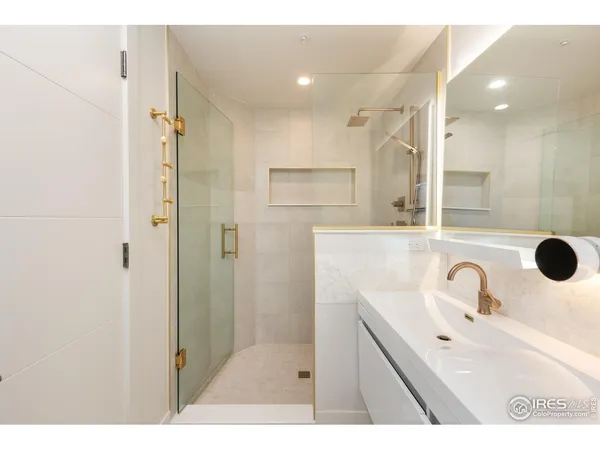 a bathroom with a sink mirror and shower