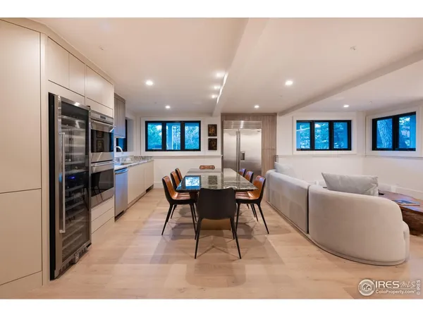 a living room with stainless steel appliances furniture and a kitchen view