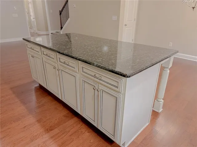 a kitchen with granite countertop white cabinets and white appliances