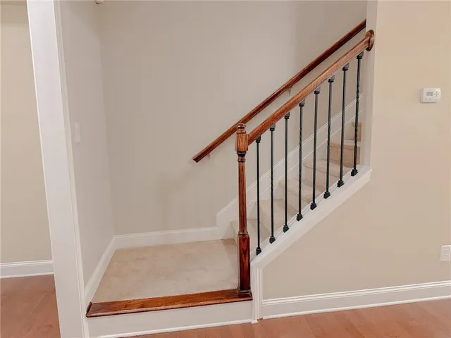a view of staircase with wooden floor and white walls