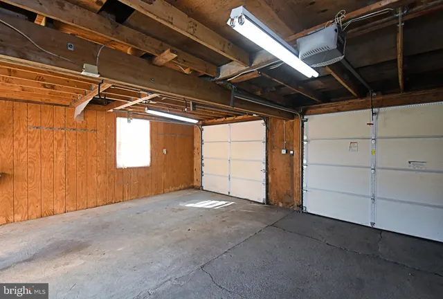 a view of a house with a big yard plants and large tree