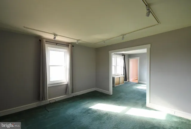 an empty room with windows and closet