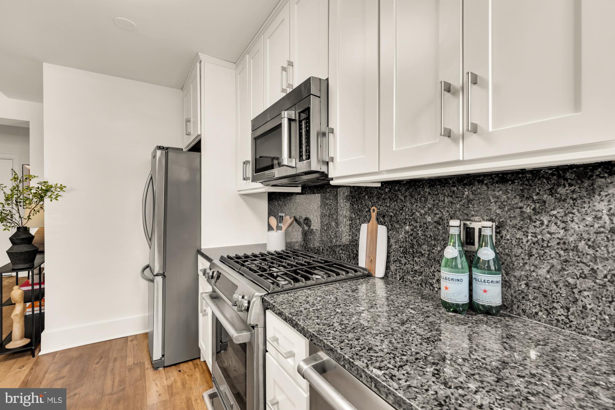 1910 Kalorama Road Northwest, Unit 302 Washington, DC 20009 - Photo 14 of 28 a kitchen with granite countertop a stove and a refrigerator