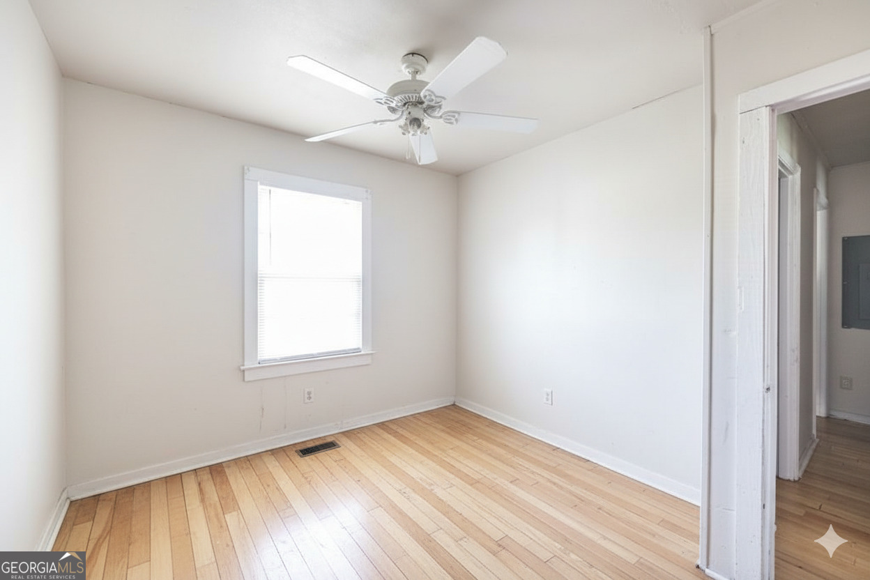 511 Forsyth Street Montezuma, GA 31063 - Photo 11 of 12 an empty room with a window and wooden floor