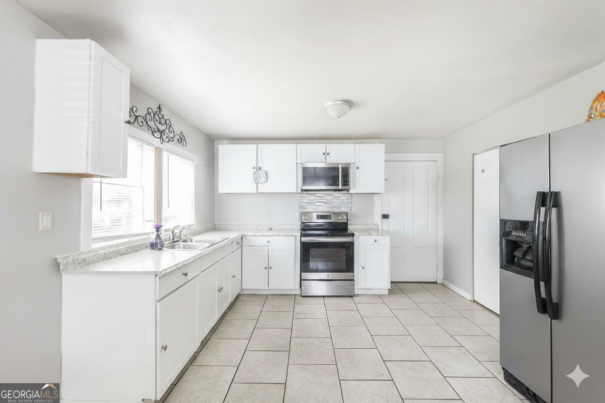 511 Forsyth Street Montezuma, GA 31063 - Photo 7 of 12 a kitchen with stainless steel appliances granite countertop a refrigerator and a sink