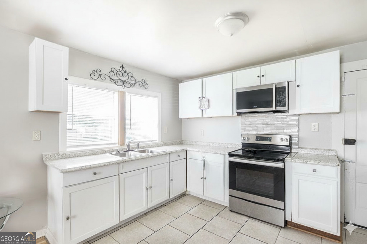 511 Forsyth Street Montezuma, GA 31063 - Photo 8 of 12 a kitchen with appliances a sink and a window