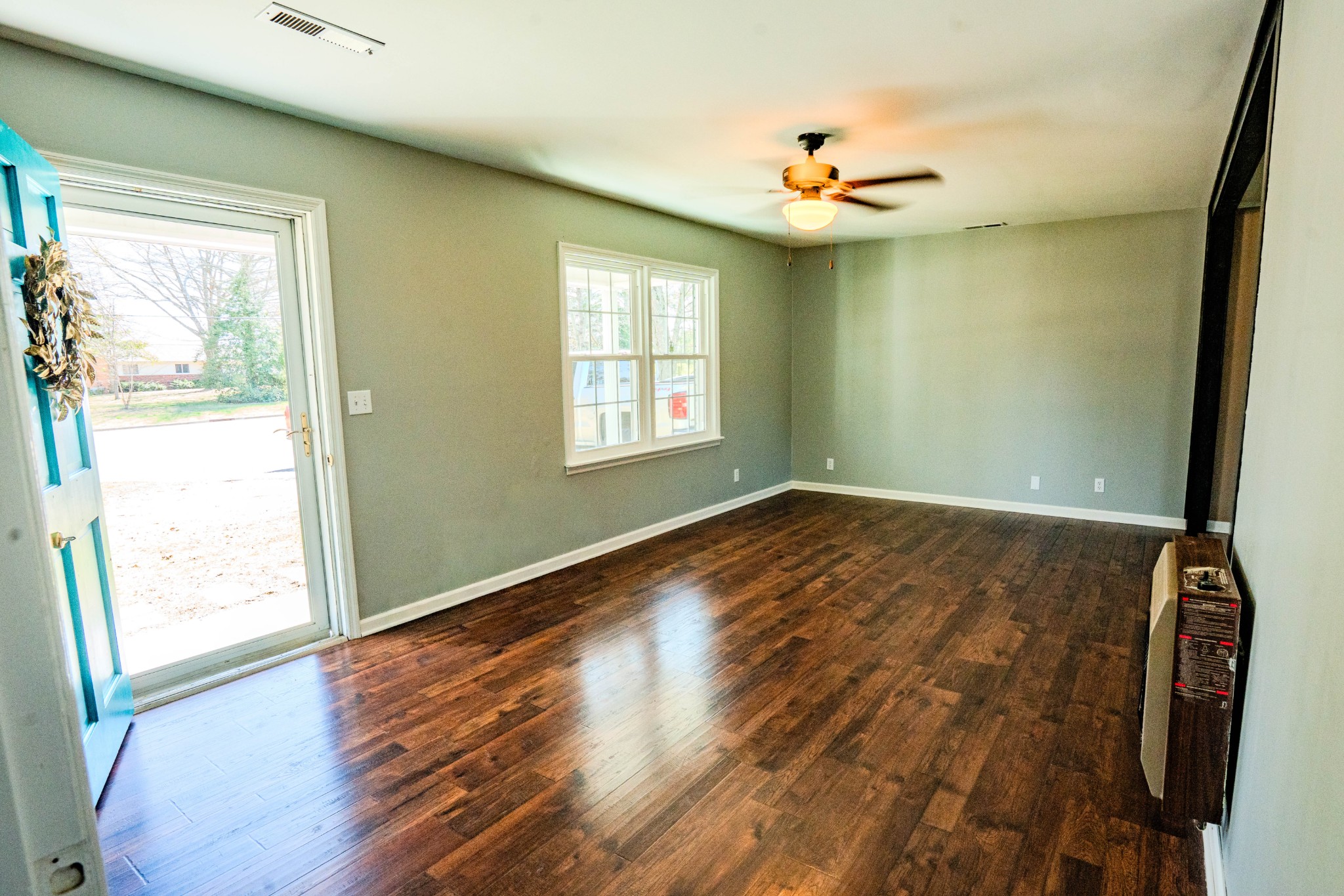 705 North Military Street Loretto, TN 38469 - Photo 8 of 16 an empty room with wooden floor and windows