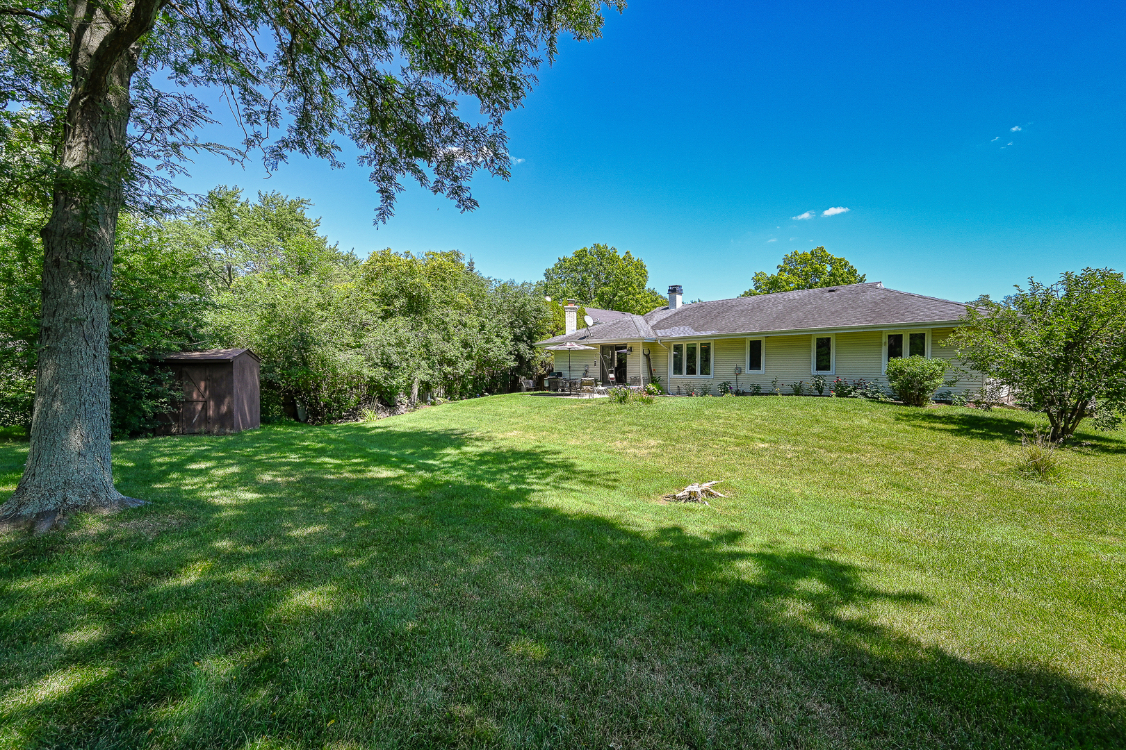 2S050 Taylor Road Glen Ellyn, IL 60137 - Photo 24 of 24 a backyard of a house with table and chairs under an umbrella
