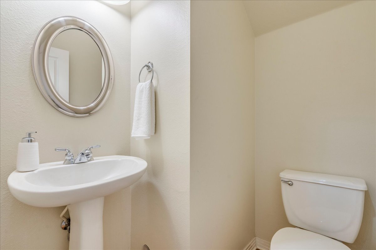 2115 Bluebonnet Lane, Unit 4A Austin, TX 78704 - Photo 11 of 29 a bathroom with a toilet a sink and a mirror