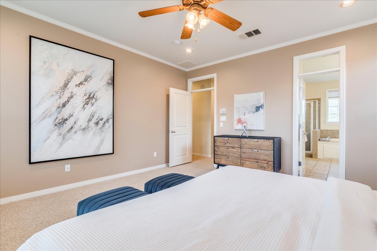 2115 Bluebonnet Lane, Unit 4A Austin, TX 78704 - Photo 14 of 29 a bedroom with a large bed and a chandelier