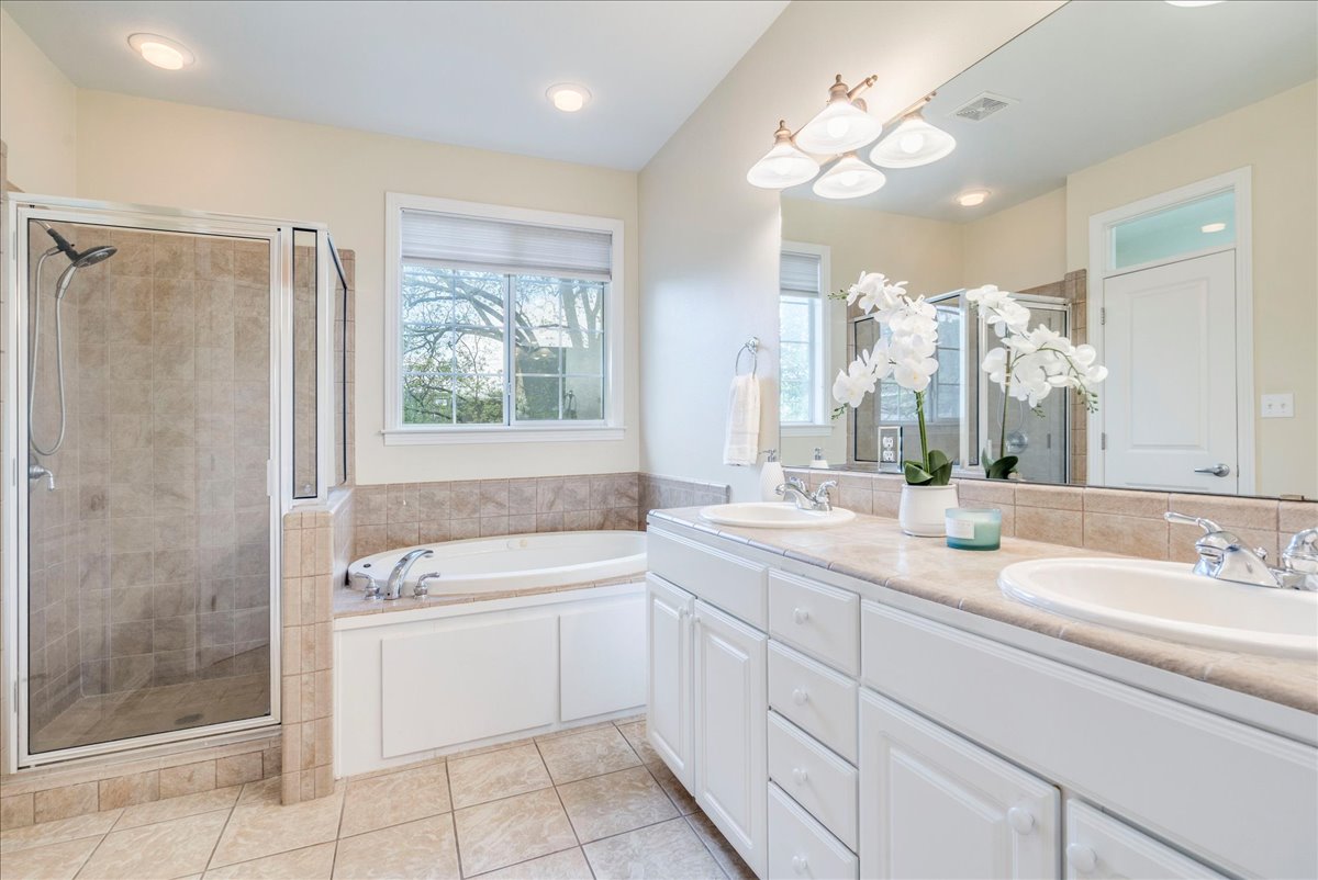 2115 Bluebonnet Lane, Unit 4A Austin, TX 78704 - Photo 15 of 29 a bathroom with a double vanity sink large mirror and a bathtub
