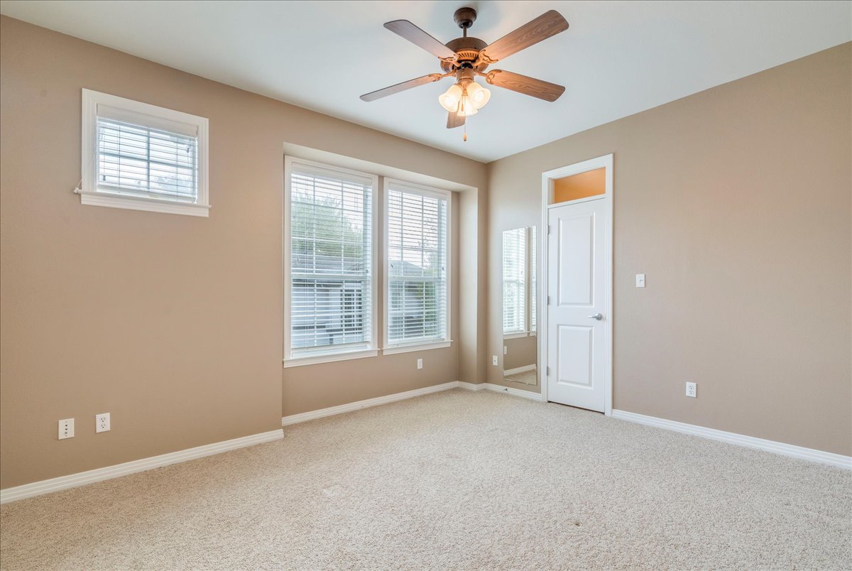 2115 Bluebonnet Lane, Unit 4A Austin, TX 78704 - Photo 19 of 29 an empty room with chandelier fan and windows
