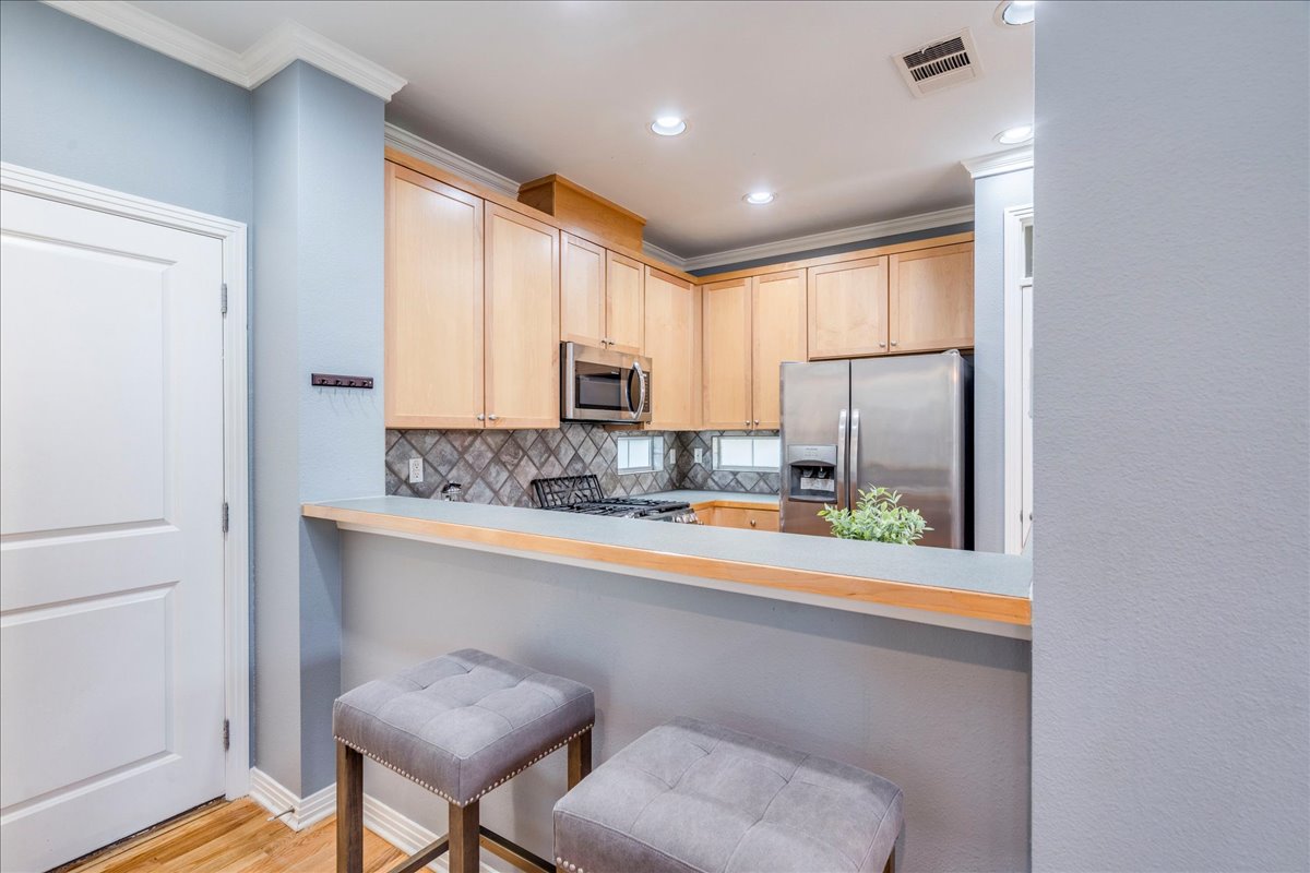 2115 Bluebonnet Lane, Unit 4A Austin, TX 78704 - Photo 6 of 29 a kitchen with stainless steel appliances a refrigerator and a stove top oven