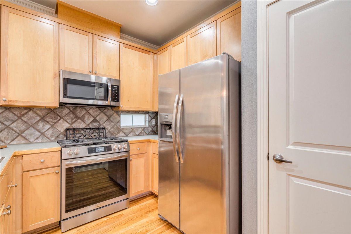 2115 Bluebonnet Lane, Unit 4A Austin, TX 78704 - Photo 8 of 29 a kitchen with stainless steel appliances granite countertop a refrigerator and a stove top oven