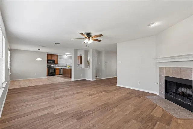 a view of empty room with wooden floor and fireplace