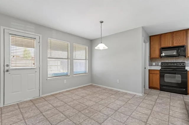 a kitchen with granite countertop a stove a sink and a refrigerator