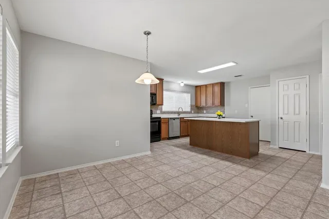 a kitchen with stainless steel appliances kitchen island granite countertop a refrigerator a sink a stove a microwave and white cabinets