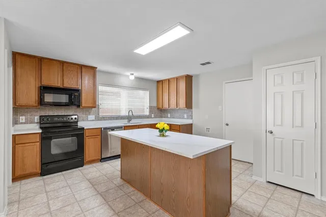a kitchen with stainless steel appliances granite countertop a stove top oven a sink a counter top space and cabinets