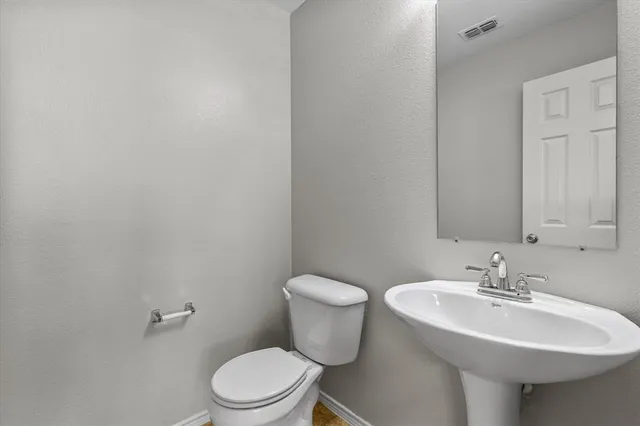 a bathroom with a sink toilet and a mirror