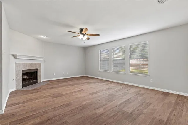 a view of an empty room with a fireplace and a window