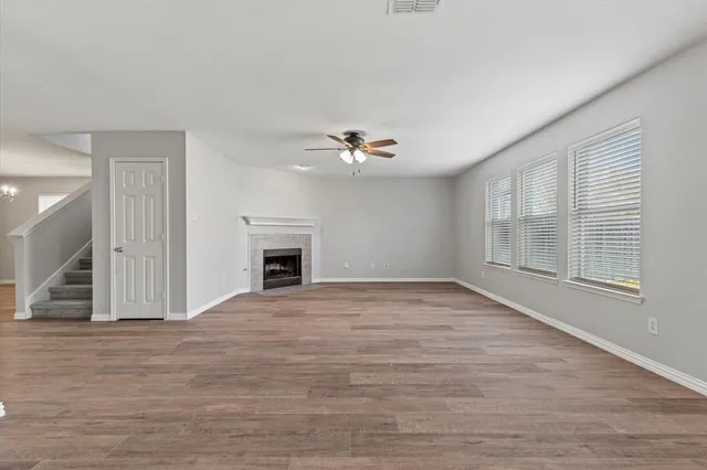 a view of an empty room with a window and fireplace