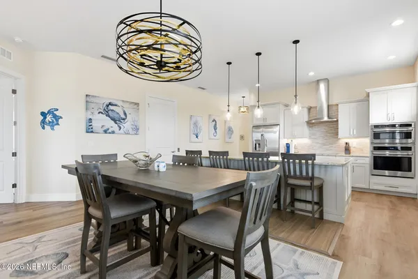 a dining room with furniture window and wooden floor
