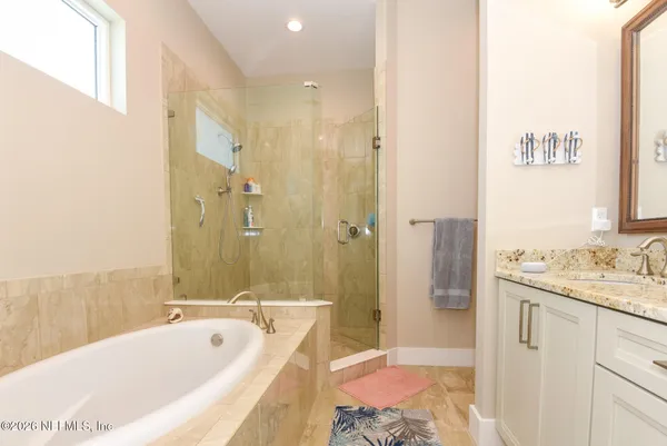 a bedroom with a bed table and a mirror