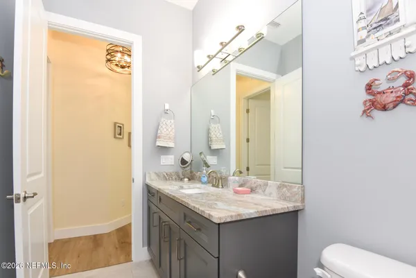 a bathroom with a granite countertop toilet sink and mirror