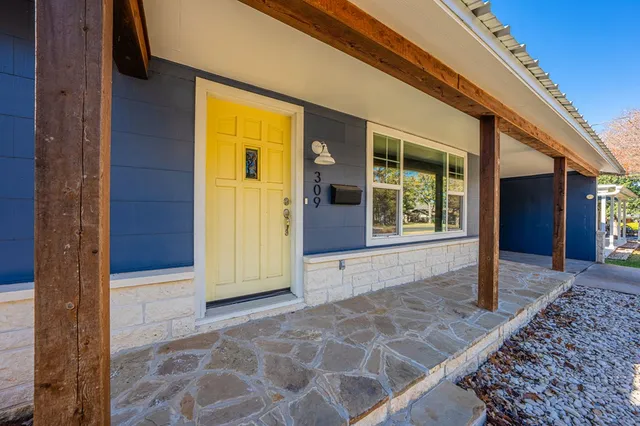 a view of hallway with a large window and wooden floor