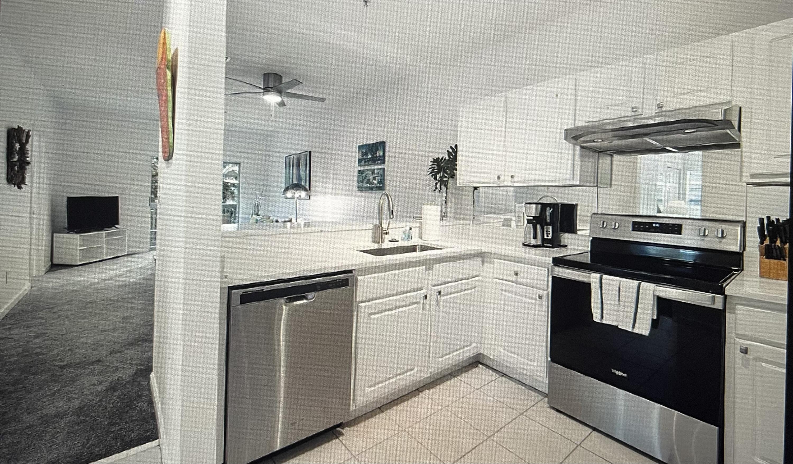 34 Heron's Watch Way, Unit 2304 Santa Rosa Beach, FL 32459 - Photo 7 of 56 a kitchen with a sink dishwasher stove and white cabinets