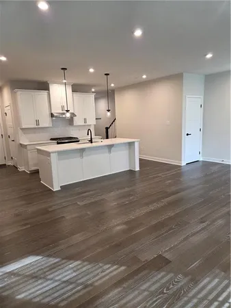 a view of kitchen with kitchen island white cabinets and center island
