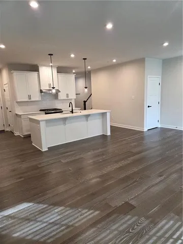 a view of kitchen with kitchen island white cabinets and center island