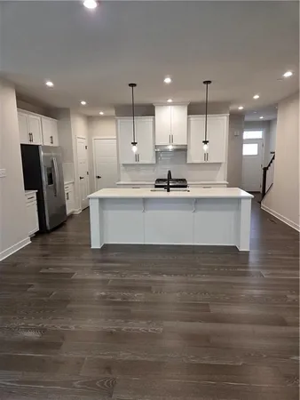 a view of kitchen with kitchen island a sink stainless steel appliances and cabinets