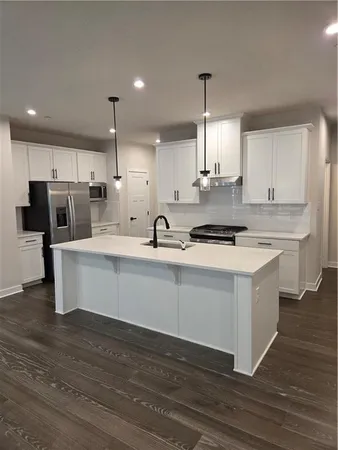 a kitchen with stainless steel appliances kitchen island granite countertop a stove a sink and a refrigerator