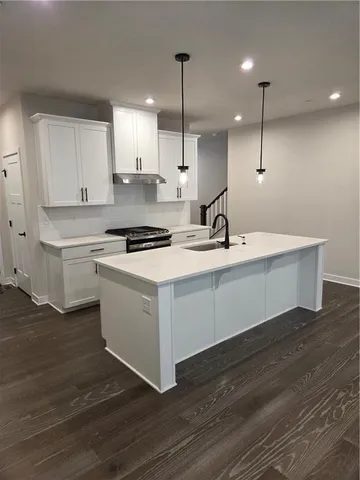 a kitchen with a sink cabinets and wooden floor