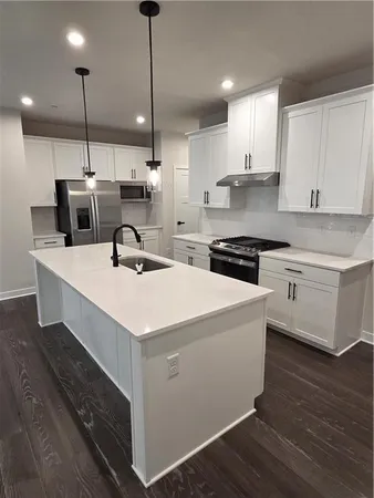 a kitchen with kitchen island a sink stainless steel appliances and cabinets